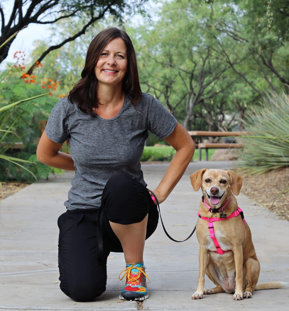 This article's author, Kim Silver, outside next to a small dog on leash.